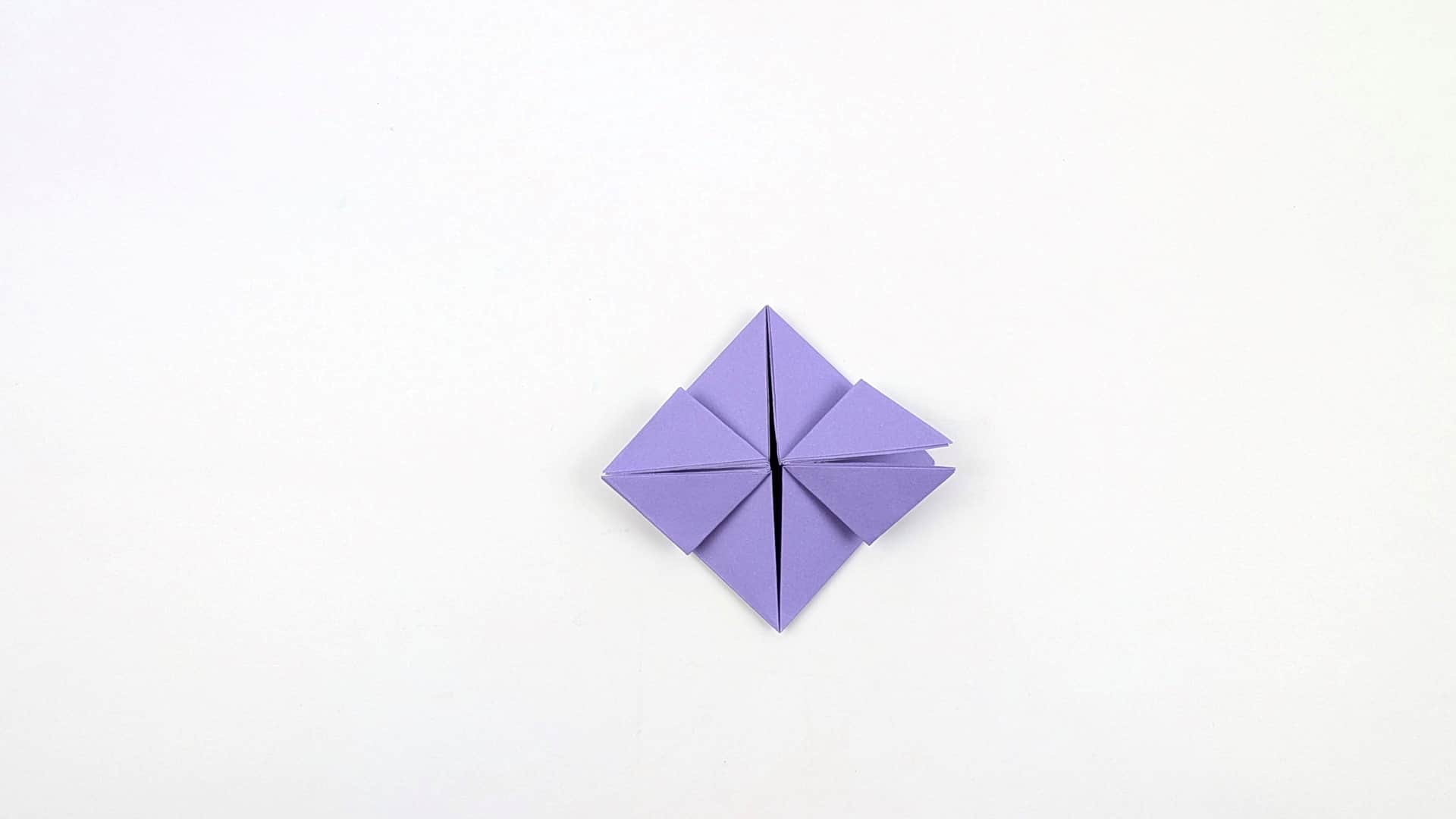 All four triangular panels are now folded flat, creating a compact diamond with 8 triangular segments visible across the front.