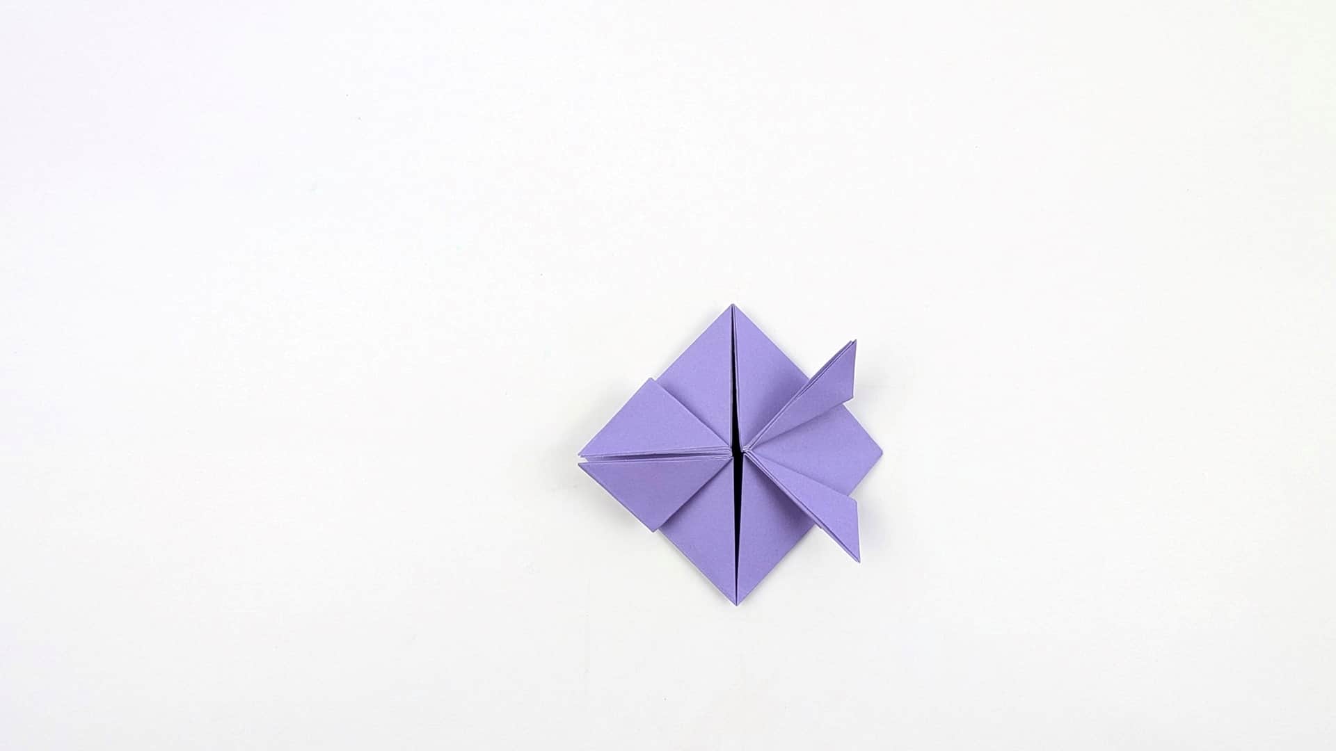Fold one corner point outward to create a small protruding triangle — this is the first leg stub.