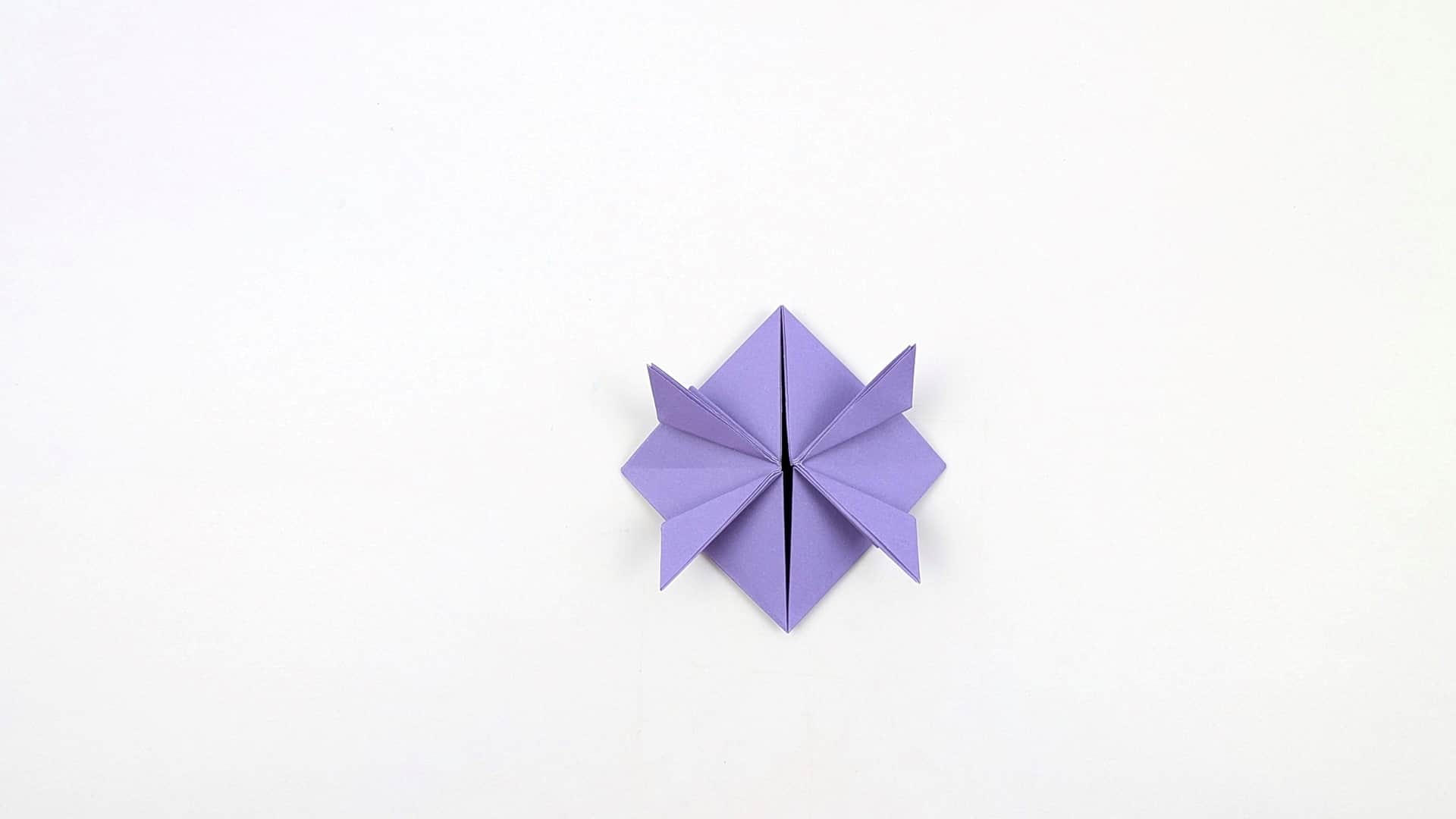 Repeat for all four corners. You now have a star or flower shape with four small triangles pointing outward at the compass points.