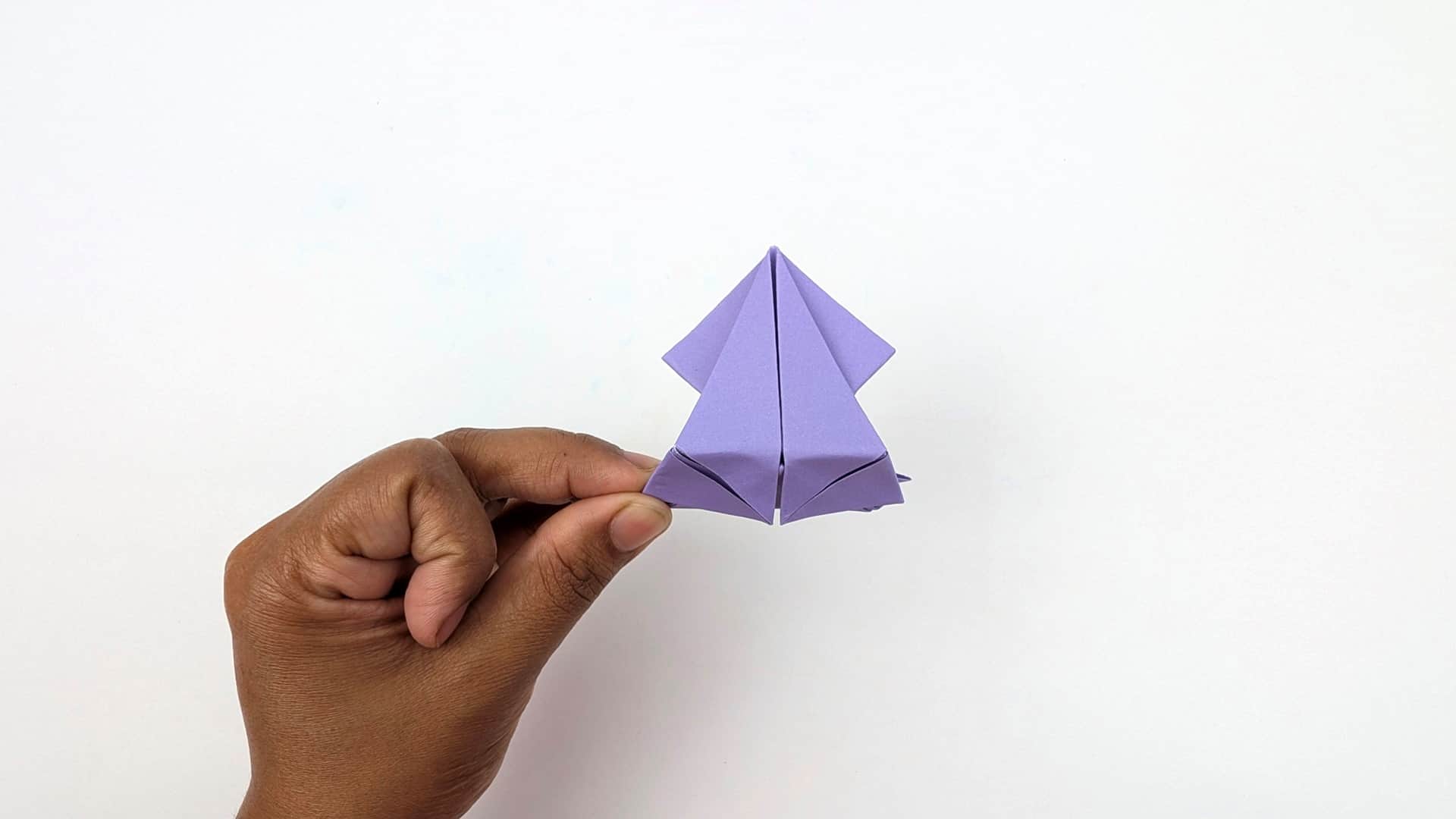 Turn the frog to show the belly and front legs from below. The spring base is visible at the bottom.