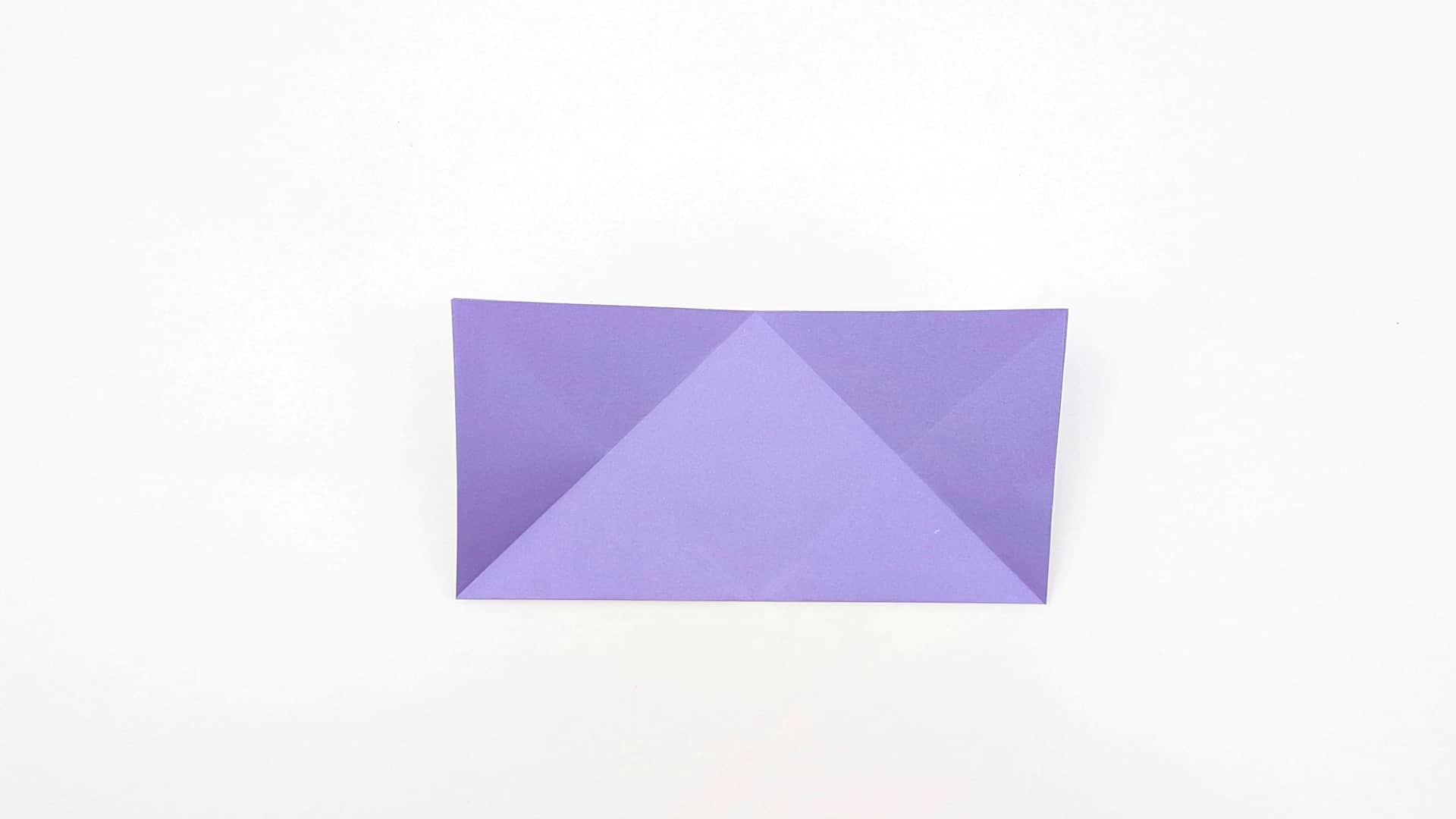 Flip the paper over. It lies flat as a rectangle with all the diagonal and horizontal crease lines now visible on this side.