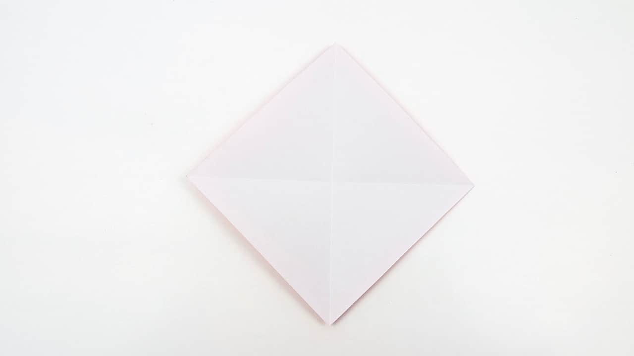 Fold the left edge to the center diagonal crease, matching the right side. This forms a kite shape.