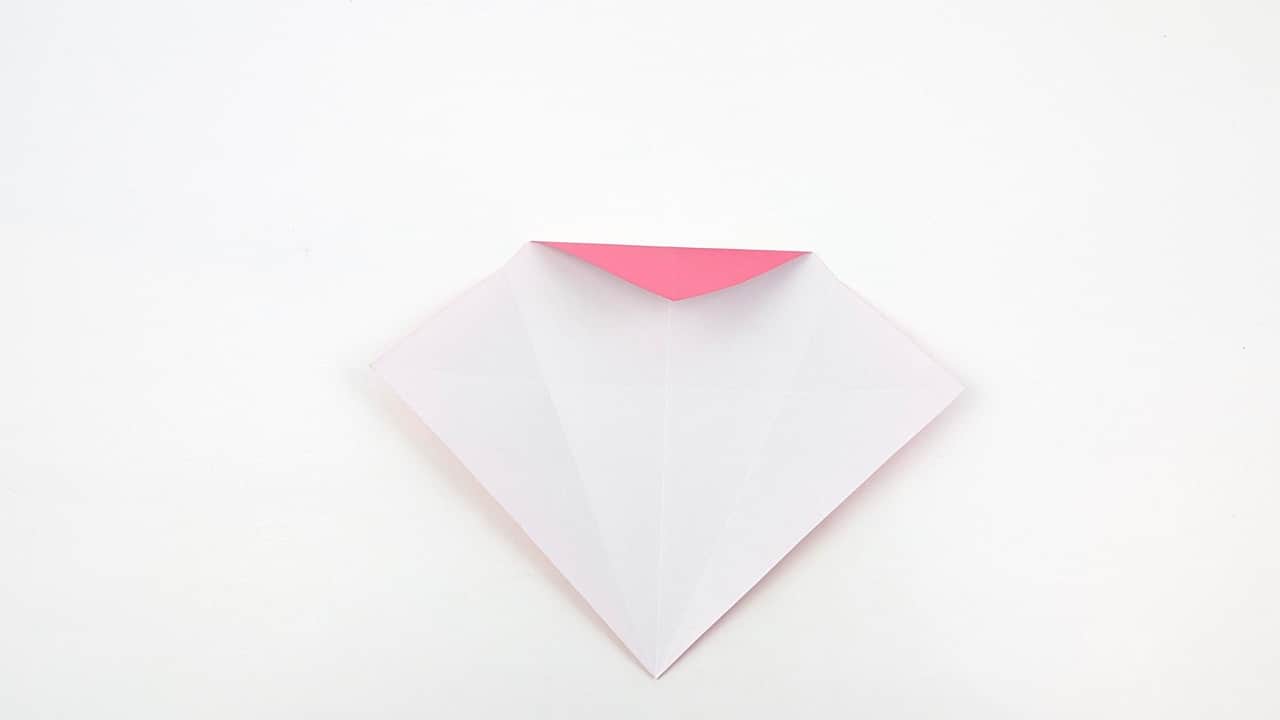 Fold the narrow top point downward. This will become the penguin's head — stop about one-quarter down from the top.