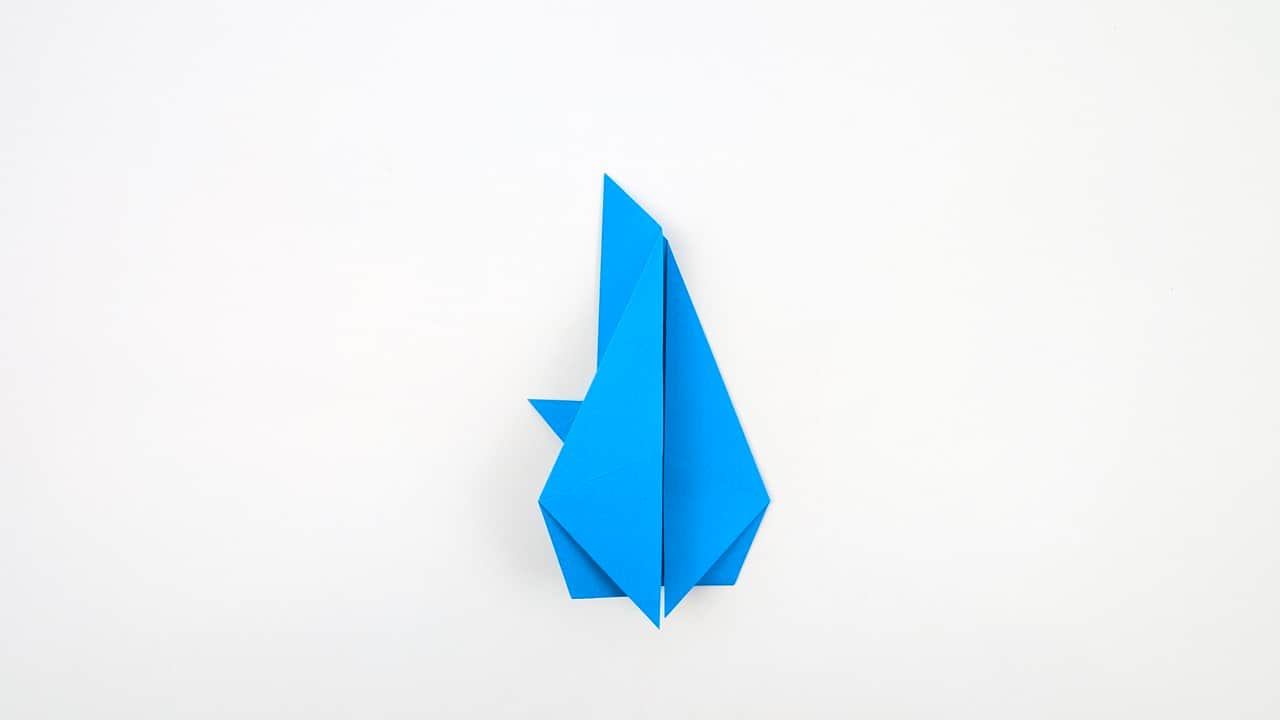 Fold the top right edge of the body inward to begin shaping the dorsal fin.